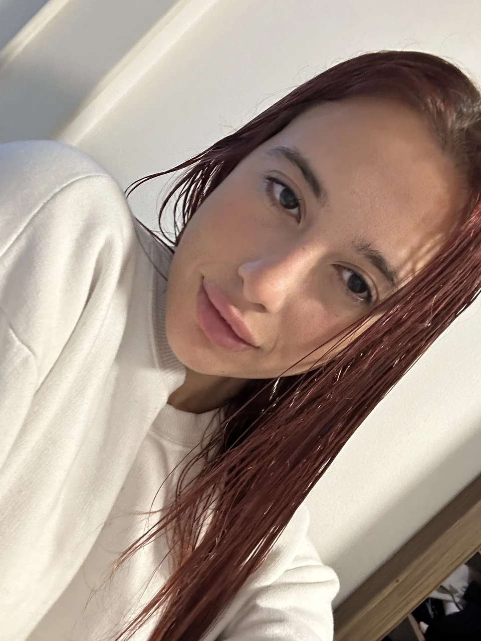 Natalye with red hair in a cream sweater